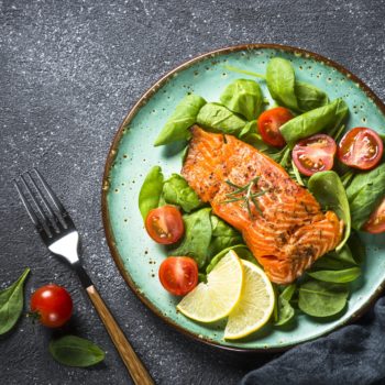 Baked salmon fish fillet with fresh salad top view
